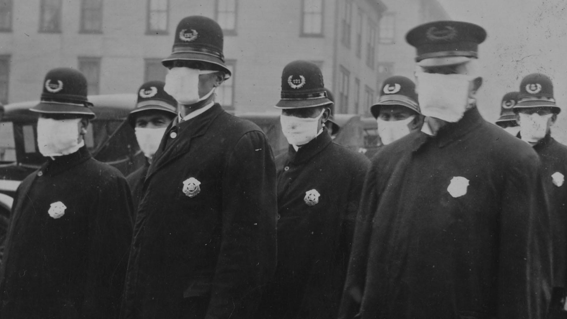 Black and white image of policemen in Seattle wearing masks made by the Red Cross. 